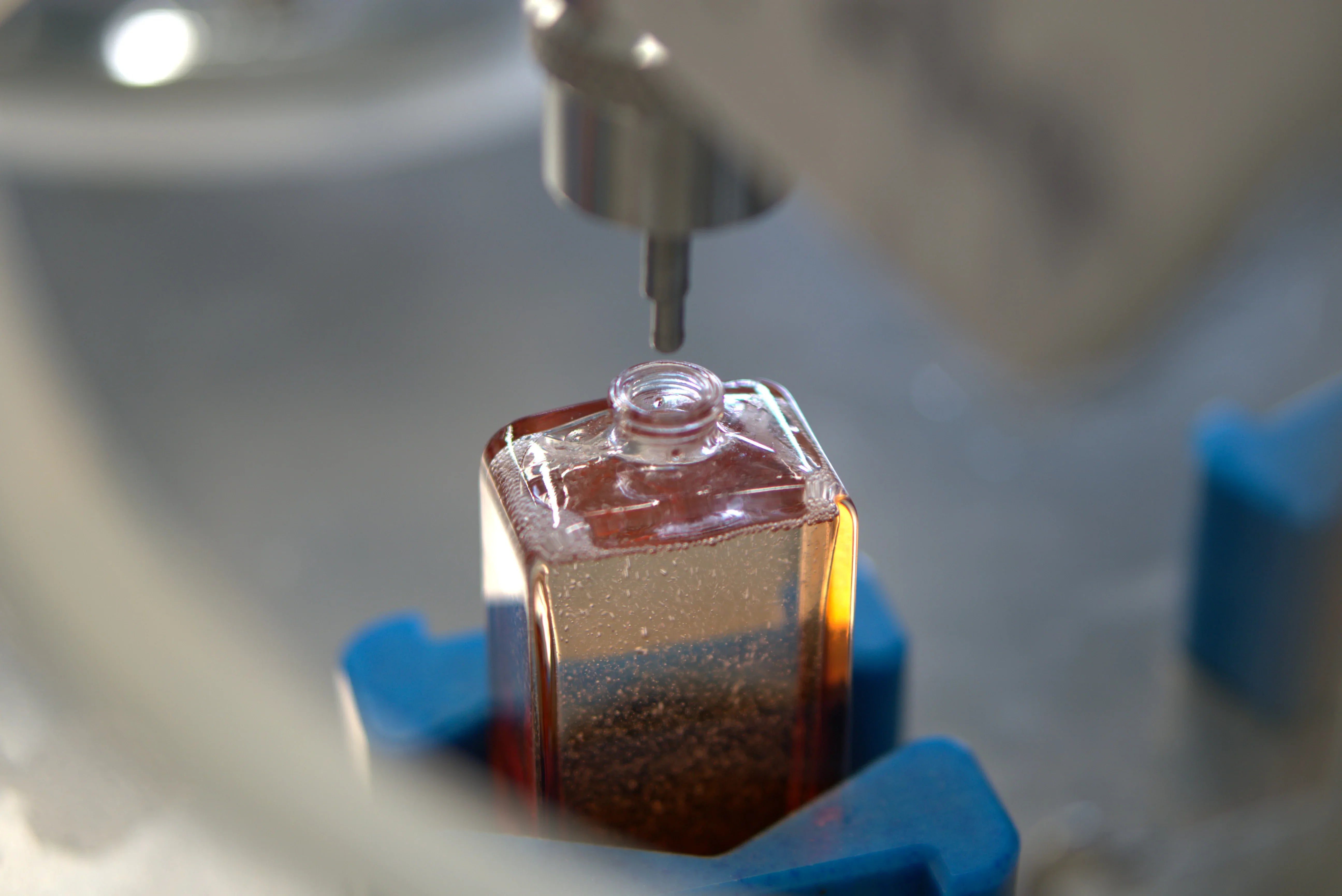 remplissage d'un flacon de parfum par une machine